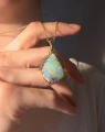 Opal w złotej zawieszce, ze szmaragdem i diamentami